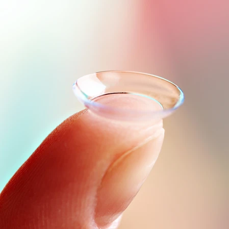 A contact lens balancing on the tip of a finger